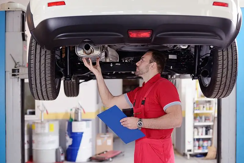 mechanic inspecting an aftermarket exhaust system